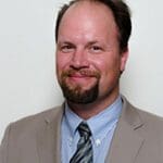 A man with a beard and mustache wearing a suit