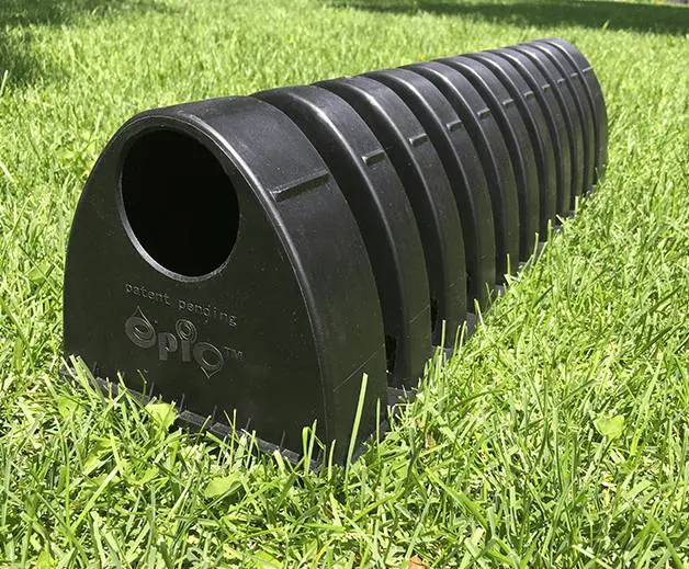 A black plastic tube sitting in the grass.