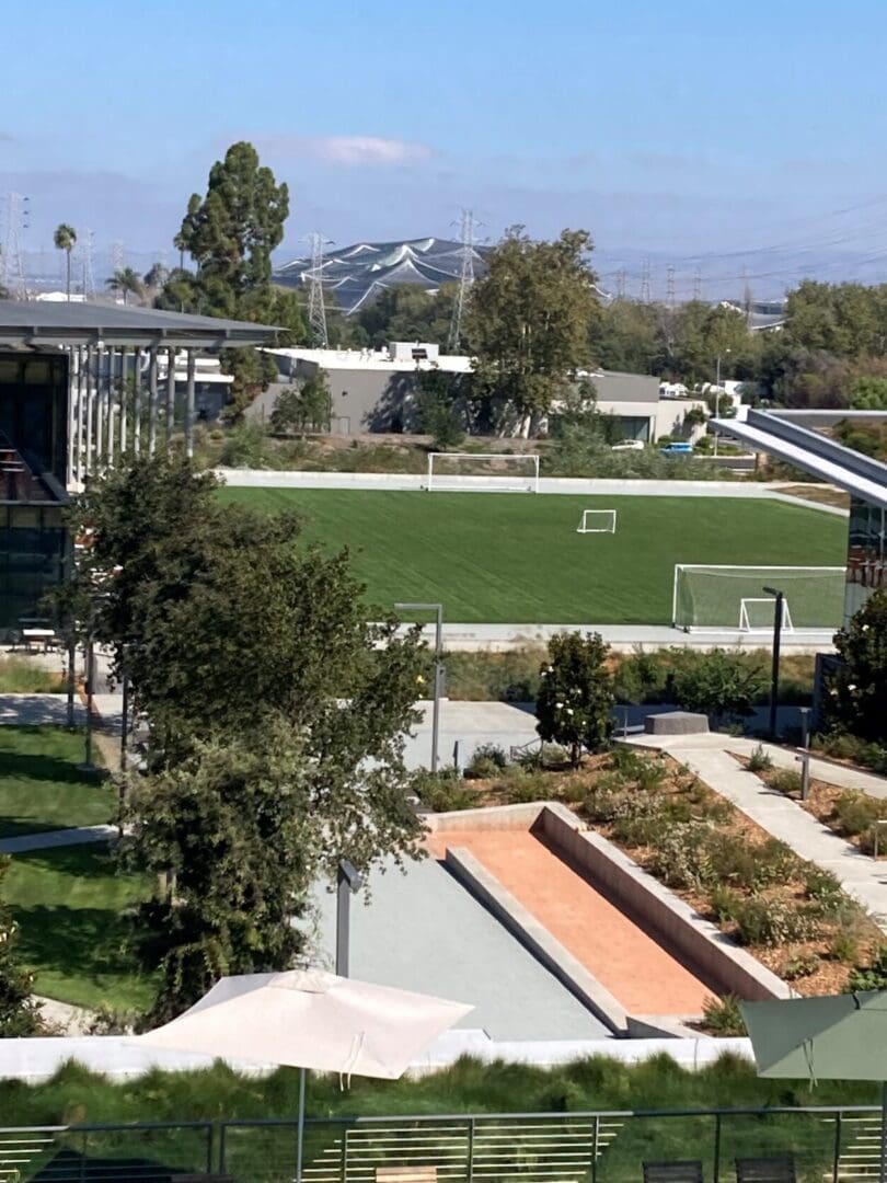 Lush green sports field with surrounding landscaping.